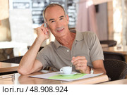 Senior having an expresso while talking on his cellphone. Стоковое фото, агентство Ingram Publishing / Фотобанк Лори