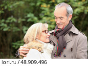 old couple wearing warm clothes in the forest and expressing tenderness. Стоковое фото, агентство Ingram Publishing / Фотобанк Лори