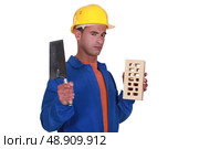 Mason holding brick and trowel. Стоковое фото, агентство Ingram Publishing / Фотобанк Лори