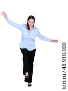 Woman pretending to walk on tight-rope. Стоковое фото, агентство Ingram Publishing / Фотобанк Лори