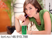 Attractive brunette drinking mint cordial. Стоковое фото, агентство Ingram Publishing / Фотобанк Лори