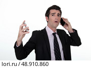 Overwhelmed businessman answering telephones. Стоковое фото, агентство Ingram Publishing / Фотобанк Лори