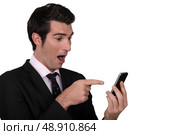 Surprised man pointing to his mobile phone. Стоковое фото, агентство Ingram Publishing / Фотобанк Лори