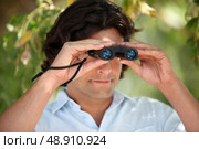 Man looking through a pair of binoculars. Стоковое фото, агентство Ingram Publishing / Фотобанк Лори
