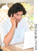 Man sat with laptop and telephone on terrace. Стоковое фото, агентство Ingram Publishing / Фотобанк Лори