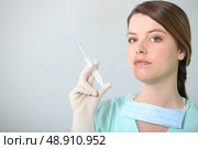 Brunette nurse holding syringe. Стоковое фото, агентство Ingram Publishing / Фотобанк Лори