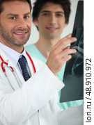 Doctor and nurse looking at X-ray. Стоковое фото, агентство Ingram Publishing / Фотобанк Лори