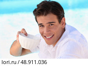 Handsome young man drinking from a bowl. Стоковое фото, агентство Ingram Publishing / Фотобанк Лори