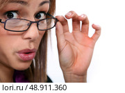 young woman looked amazed, she’s lowering her glasses. Стоковое фото, агентство Ingram Publishing / Фотобанк Лори