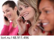 Young women talking on their mobile phones. Стоковое фото, агентство Ingram Publishing / Фотобанк Лори