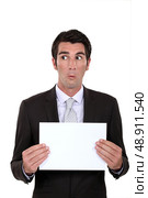 A businessman presenting a poster with a weird facial expression. Стоковое фото, агентство Ingram Publishing / Фотобанк Лори