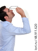 Businessman peering at his glasses. Стоковое фото, агентство Ingram Publishing / Фотобанк Лори