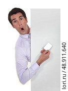 man hiding showing business card playing the fool. Стоковое фото, агентство Ingram Publishing / Фотобанк Лори