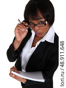 portrait of black businesswoman looking upwards holding pen and notepad. Стоковое фото, агентство Ingram Publishing / Фотобанк Лори