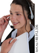 Smiling woman wearing a headset and holding a notebook. Стоковое фото, агентство Ingram Publishing / Фотобанк Лори