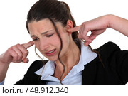 Woman being driven crazy by loud noise. Стоковое фото, агентство Ingram Publishing / Фотобанк Лори