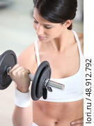 a woman lifting a barbell. Стоковое фото, агентство Ingram Publishing / Фотобанк Лори