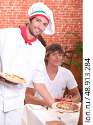 smiling pizzaiolo serving customers. Стоковое фото, агентство Ingram Publishing / Фотобанк Лори