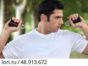 Man performing wrist exercise. Стоковое фото, агентство Ingram Publishing / Фотобанк Лори
