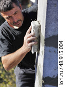 Mason smoothing wall. Стоковое фото, агентство Ingram Publishing / Фотобанк Лори