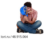 A male construction worker sitting on the floor. Стоковое фото, агентство Ingram Publishing / Фотобанк Лори