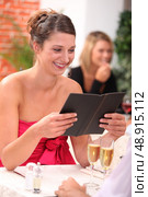 woman looking at the menu at a restaurant. Стоковое фото, агентство Ingram Publishing / Фотобанк Лори