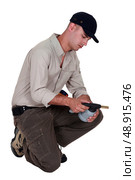 A manual worker examining a welding torch. Стоковое фото, агентство Ingram Publishing / Фотобанк Лори
