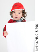 Child dressed as a builder with a blank board. Стоковое фото, агентство Ingram Publishing / Фотобанк Лори