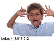 Young boy pulling a face and sticking his tongue out. Стоковое фото, агентство Ingram Publishing / Фотобанк Лори