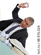 Frustrated businessman throwing scrunched-up paper. Стоковое фото, агентство Ingram Publishing / Фотобанк Лори