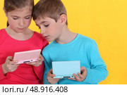Two kids playing video games. Стоковое фото, агентство Ingram Publishing / Фотобанк Лори