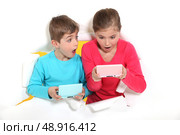 Sibling playing video games. Стоковое фото, агентство Ingram Publishing / Фотобанк Лори
