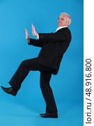 Man pushing invisible furniture. Стоковое фото, агентство Ingram Publishing / Фотобанк Лори