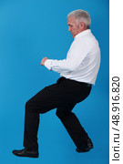 Senior man pulling invisible object. Стоковое фото, агентство Ingram Publishing / Фотобанк Лори