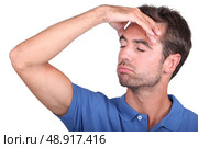Studio shot of a man with a headache. Стоковое фото, агентство Ingram Publishing / Фотобанк Лори