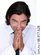 Man in a shirt and tie pressing his hands together in glee. Стоковое фото, агентство Ingram Publishing / Фотобанк Лори
