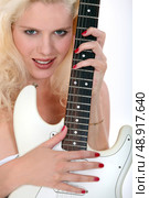 Blond woman holding electric guitar. Стоковое фото, агентство Ingram Publishing / Фотобанк Лори