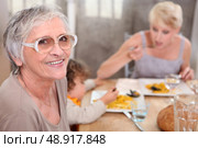 Grandma joins an informal family supper. Стоковое фото, агентство Ingram Publishing / Фотобанк Лори