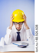 Young engineer looking at drawings. Стоковое фото, агентство Ingram Publishing / Фотобанк Лори