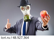 Businessman with gas mask and apple. Стоковое фото, агентство Ingram Publishing / Фотобанк Лори