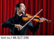 Violin player playing the intstrument. Стоковое фото, агентство Ingram Publishing / Фотобанк Лори