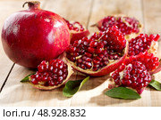 pomegranate with leafs on wooden table. Стоковое фото, агентство Ingram Publishing / Фотобанк Лори