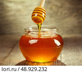 Honey pouring into bowl on wooden. Стоковое фото, агентство Ingram Publishing / Фотобанк Лори