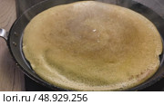 A golden pancake is baked on a griddle. A hot pancake with steam coming from it. Cooking breakfast. Стоковое видео, видеограф Наталия Попова / Фотобанк Лори