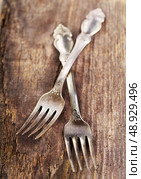 Vintage silverware forks lying on rustic wooden table. Стоковое фото, агентство Ingram Publishing / Фотобанк Лори