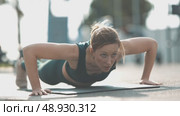 Adult athletic woman doing push ups on yoga mat outdoors. Стоковое видео, видеограф Константин Шишкин / Фотобанк Лори