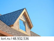 House Exterior. Roof Window. Second floor among blue sky. Mansard attic. Newly build houses. Gable roof with skylight, asphalt roofing, shingles. Residential Home. Vinyl Siding. Polymeric roof-tiles. Стоковое AI-изображение, AI-художник Марина Демидюк / Фотобанк Лори