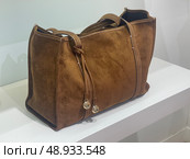 Brown suede handbag on store display. Редакционное фото, фотограф Данил Руденко / Фотобанк Лори