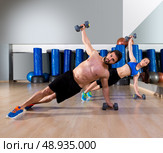 Dumbbells push-ups pushups couple at fitness gym workout. Стоковое фото, агентство Ingram Publishing / Фотобанк Лори