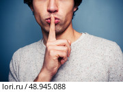 Young man is signalling hush. Стоковое фото, агентство Ingram Publishing / Фотобанк Лори